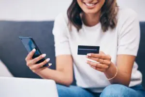 woman paying with credit card on mobile phone