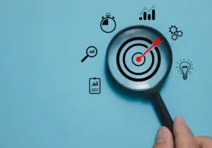 magnifying glass over targeting board with arrow in the middle, representing audience targeting