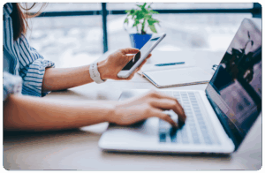 woman using phone and laptop