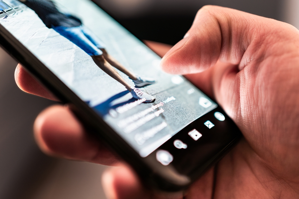 person scrolling on phone and watching video advert