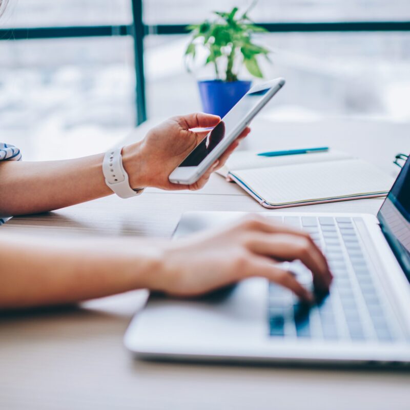 laptop and phone, looking at website