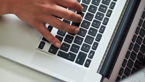 person working on website content on laptop