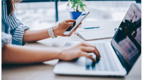 woman using phone and laptop