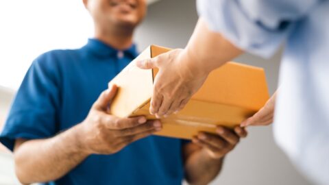 Close,Up,Parcel,In,Hand,Of,Blue,Uniform,Delivery,Man