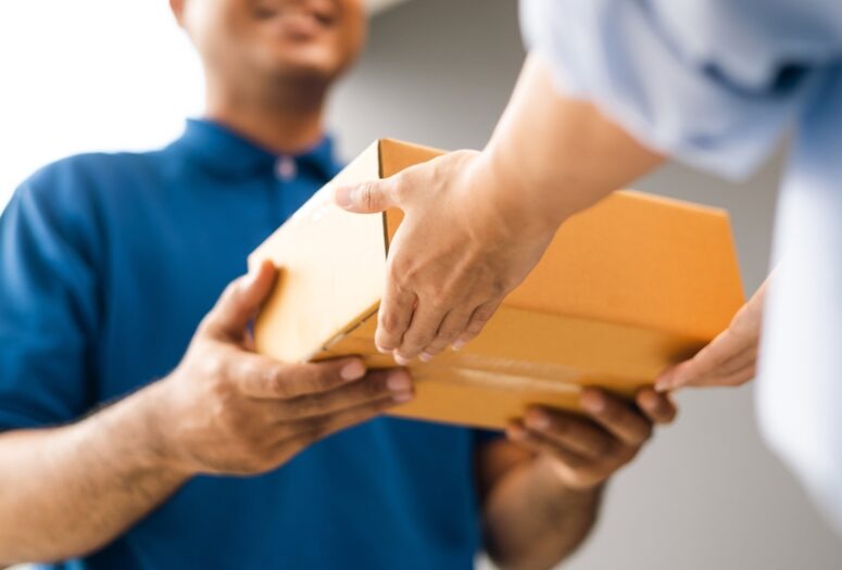 Blog 2 close,up,parcel,in,hand,of,blue,uniform,delivery,man