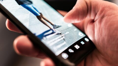 person scrolling on phone and watching video advert