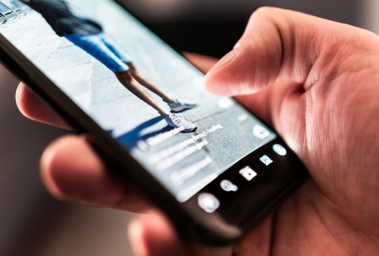person scrolling on phone and watching video advert